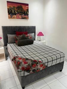 Manshu Guest House في هراري: غرفة نوم مع سرير وبطانية مقلية