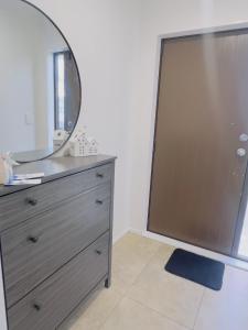 a mirror on top of a dresser in a room at Room available near airport in Takanini +2 photos