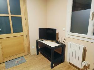 a desk with a television on it in a room at Studio au cœur de Cerdagne in Bourg-Madame