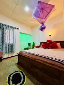 1 dormitorio con 1 cama con sombrilla morada en Soldara Gedara, en Hikkaduwa