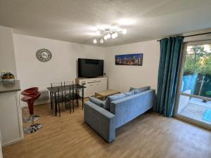 a living room with a blue couch and a table at Appart Borderouge city in Toulouse