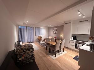 a living room with a dining room table and a kitchen at R&R/staycationNew flat at Vervet in Tromsø +19 photos