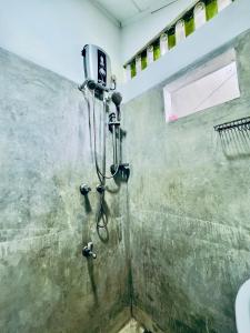 y baño con ducha y cabezal de ducha. en Soldara Gedara, en Hikkaduwa
