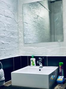a white sink in a bathroom with a mirror at Champagne apartment on Main in Johannesburg