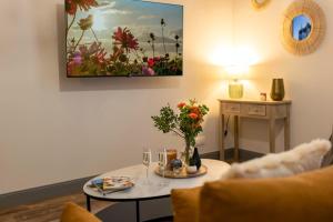 a living room with a table with a vase of flowers at La Cour du Cygne - By PrestiPlace in Tours