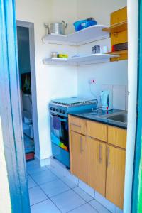 a kitchen with a stove and a sink at Haydenco Suites Signatuture Mall Syokimau in Nairobi