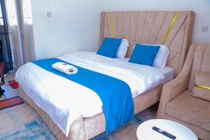 a bedroom with two beds with blue and white sheets at Haydenco Suites Signatuture Mall Syokimau in Nairobi