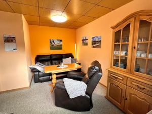 a living room with leather chairs and a wooden table at Ferienhaus Hentzschel in Kurort Altenberg