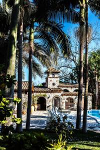budynek z wieżą zegarową i palmami w obiekcie B&B La Villa w mieście Giardini Naxos