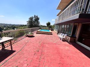 a brick patio with a swimming pool on a house at Honeyhills Excellence Resort E in Roodepoort