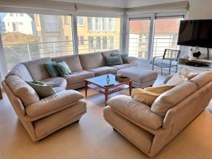 a living room with two couches and a tv at Windjammer A3 - Sea View in Koksijde