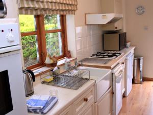 a kitchen with a sink and a stove at Westacre Lodge in Auchterarder