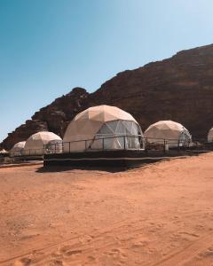 three domes in a desert with a mountain in the background at Wadi Rum The ARC camp in Wadi Rum +51 photos