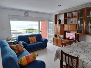 a living room with a blue couch and a table at Apartamento frente a la Playa in Suances
