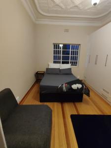 a bedroom with a bed and a couch and a window at sunnyday in Johannesburg +6 photos