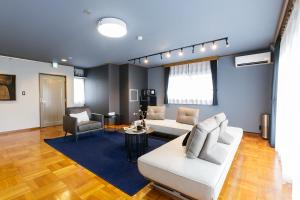 a living room with a white couch and a table at Kami-Iida STAY in Nagoya