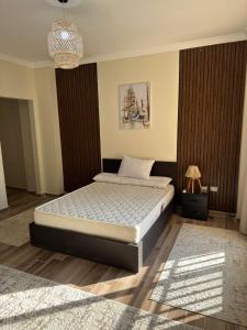 a bedroom with a bed and a chandelier at Cairo in Madīnat ash Shurūq