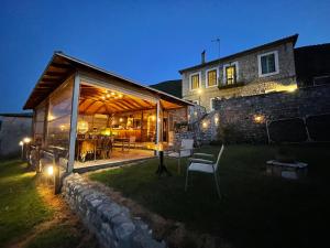 a stone house with a pavilion in a yard at night at Gerofotis Traditional Guesthouse est 1892 - Close to Aigio, Akoli, Selianitika in Lákka