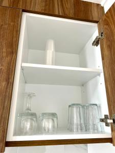 a cabinet filled with glass jars and glasses at Rotorua Stay in Rotorua
