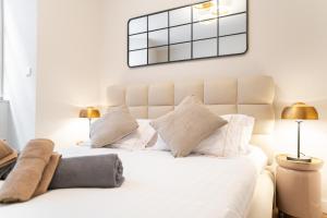 une chambre avec un lit blanc avec des oreillers blancs dans l'établissement La Tigresse Colmar Centre, à Colmar