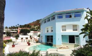 a blue building with a swimming pool in front of it at Romantica Room & SPA in Ischia