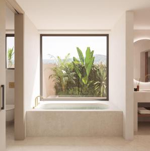a bathroom with a bath tub with a large window at Can Jaume by Ocean Drive in Ibiza Town
