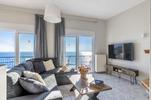 a living room with a couch and a television at Andromachi's house in Loutraki