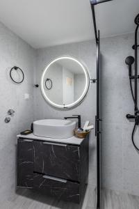 a bathroom with a sink and a mirror at Andromachi's house in Loutraki +26 photos