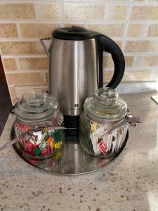 a tea kettle and two glass containers on a tray at Grazioso monolocale a Sestriere in Sestriere