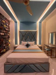 a bedroom with a large bed and a table at Gulberg Inn Hotel Lahore in Lahore