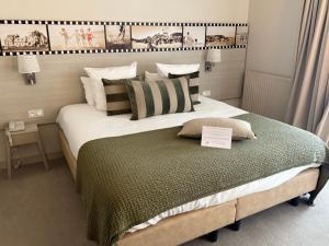 a bedroom with a large bed with a sign on it at Best Western Les Bains Hotel et SPA in Perros-Guirec