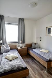 two beds in a room with a window at Apartments Haus Daniela in Cochem