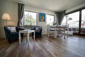 a living room with chairs and tables and windows at Apartments Haus Daniela in Cochem