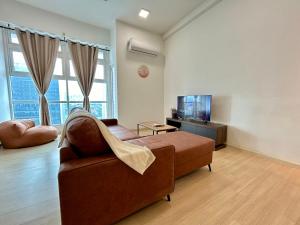 a living room with a couch and a television at Sunway Giza Nexis 1-10pax 4Qbed Kota Damansara Tropicana Mall in Petaling Jaya