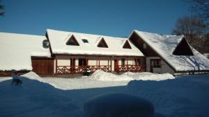 a house covered in snow with a person in front of it at Apartmán Route 18 in Liptovský Mikuláš +24 photos