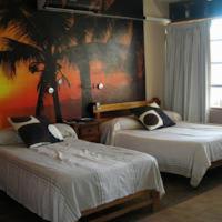 a bedroom with two beds and a palm tree on the wall at El Merlin - Cabo Blanco in Cabo Blanco