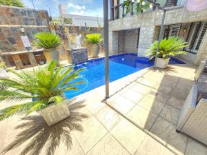 a swimming pool with palm trees and a fountain at Sleep Haven in Johannesburg