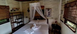 a bedroom with a bed with a swan on it at Dreamer Resort in San Vicente