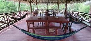 a wooden table and hammock in a tent at Dreamer Resort in San Vicente
