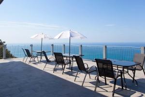 a patio area with chairs, tables and umbrellas at Hotel Due Gemelli in Riomaggiore