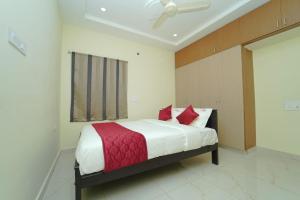 a bedroom with a large bed with red pillows at Pinaka Grand Home Stay in Tirupati +4 photos