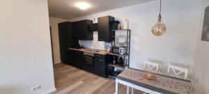 a small kitchen with black cabinets and a table at Burgau Apartments Modern & Renovated in Jena +11 photos