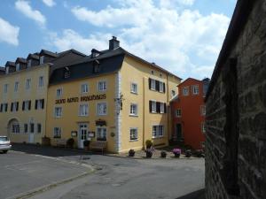 Un bâtiment jaune avec les mots san roosters dans l'établissement Hotel zum alten Brauhaus, à Dudeldorf