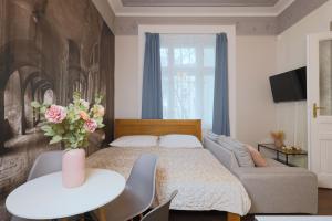 a bedroom with a bed and a couch and a table at Janackovo - Riverside Residence in Prague