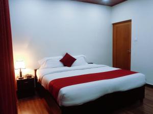 a bedroom with a large bed with a red blanket at Ghala Residency in Munnar