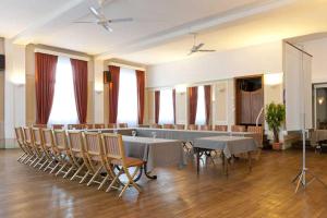 a large room with tables and chairs and a stage at Logis Le Cheval Rouge in Sainte-Menehould