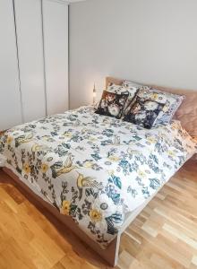 a bedroom with a bed with a floral bedspread at ENTRE GUILLEMETS, Terrasse privée, 2 chambres, Parking privé, proche de Paris in Brétigny-sur-Orge