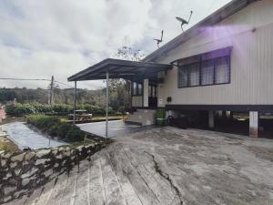 a building with a patio with a large umbrella at Rizkie homestay in Tanah Rata