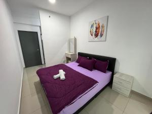 a white teddy bear sitting on a purple bed at Humaira - Metropol in Bukit Mertajam +24 photos