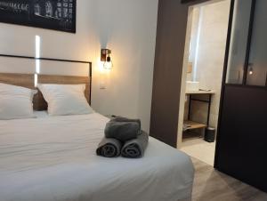 una camera d'albergo con un letto e una borsa sopra di CoLiving des Moulins sur Crémieu 3étoiles - Proche de Lyon & Bugey a Crémieu